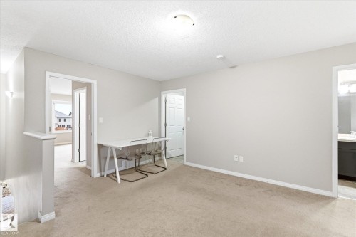 This open space features light-colored walls and carpeting, with a ceiling light fixture - 1668 Chapman Way, Edmonton, AB - Indoor Photo Showing Other Room