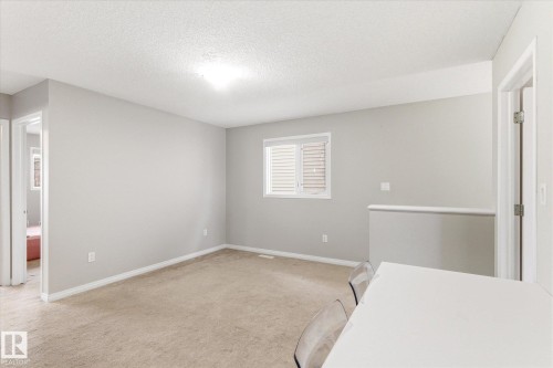 This room features neutral-toned carpet, light grey walls, and a window with blinds - 1668 Chapman Way, Edmonton, AB - Indoor Photo Showing Other Room
