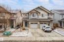 This property features a two-story exterior with light-colored siding and stone accents - 1668 Chapman Way, Edmonton, AB  - Outdoor With Facade 