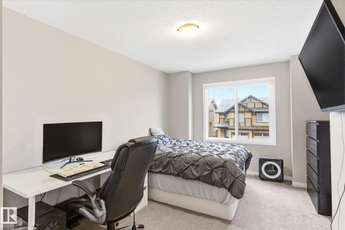 The property features a room with light-colored walls and a window offering views of nearby residences - 1668 Chapman Way, Edmonton, AB - Indoor