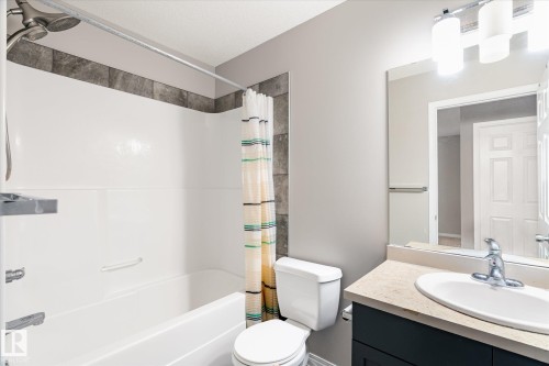 The bathroom features a white bathtub and shower with a tiled surround - 1668 Chapman Way, Edmonton, AB - Indoor Photo Showing Bathroom