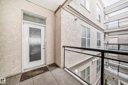 The property features a white entrance door with a frosted glass insert and transom window, set on a textured exterior wall - 