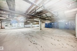 The property features a concrete parking garage with exposed overhead piping - 