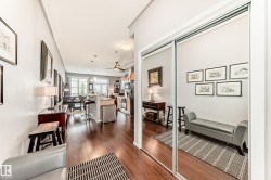 The property features rich hardwood flooring throughout the main living areas, a ceiling fan, and a kitchen with stainless steel appliances - 