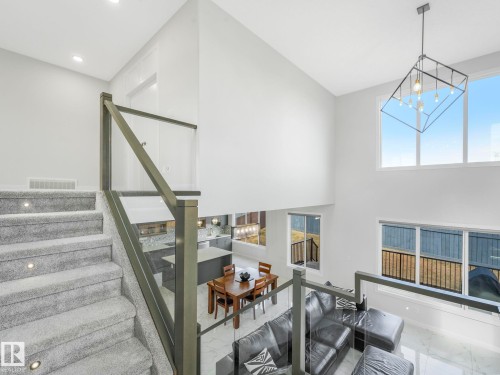 The property features a spacious open-concept interior with high ceilings and large windows providing abundant natural light - 1104 152 Avenue, Edmonton, AB - Indoor Photo Showing Other Room