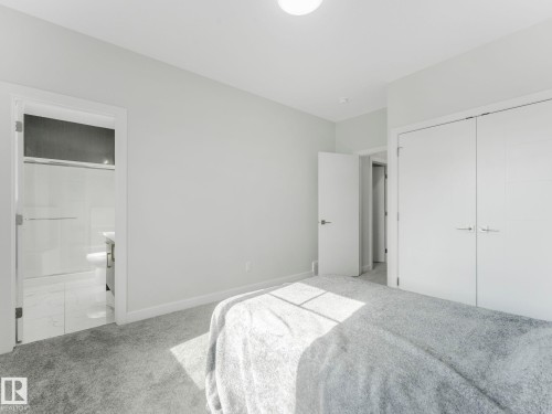 This room features a neutral color palette with light-colored walls and grey carpeting - 1104 152 Avenue, Edmonton, AB - Indoor Photo Showing Bedroom