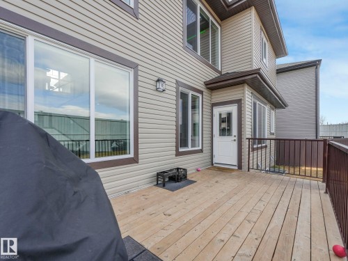 The property features a spacious deck with wood flooring and a brown metal railing - 1104 152 Avenue, Edmonton, AB - Outdoor With Deck Patio Veranda With Exterior
