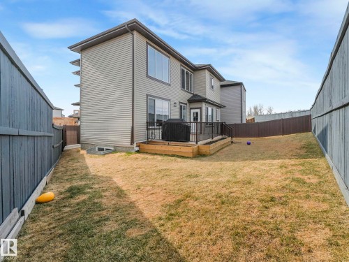 The property features an extensive backyard with a deck, a lawn, and privacy fencing - 1104 152 Avenue, Edmonton, AB - Outdoor With Deck Patio Veranda With Exterior