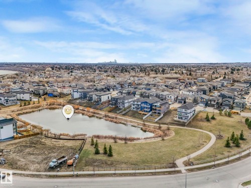 This property offers a desirable location within a developed community, featuring a pond and surrounding green space with established trees - 1104 152 Avenue, Edmonton, AB - Outdoor With View
