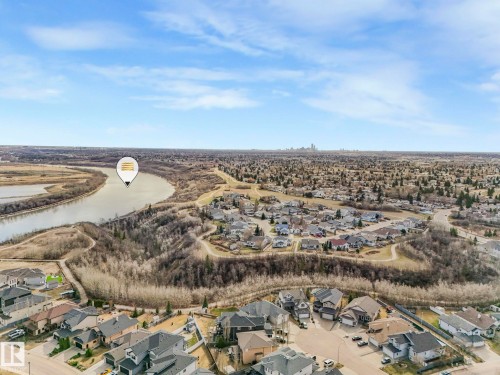 This aerial view showcases the property's proximity to a winding river, surrounded by extensive natural areas - 1104 152 Avenue, Edmonton, AB - Outdoor With View