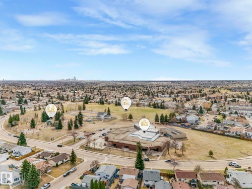 This aerial view showcases the property's advantageous location within a neighborhood featuring extensive green spaces and mature trees - 1104 152 Avenue, Edmonton, AB - Outdoor With View