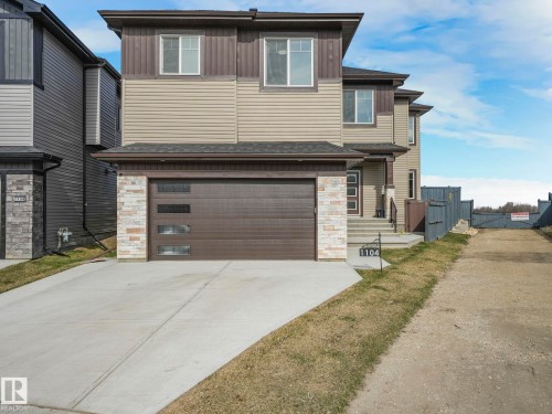 This property features a two-story exterior with horizontal siding and stone accents - 1104 152 Avenue, Edmonton, AB - Outdoor