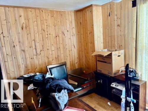 This room features wood paneling on the walls and a light-colored ceiling - 4809 53 Ave, Willingdon, AB - Indoor
