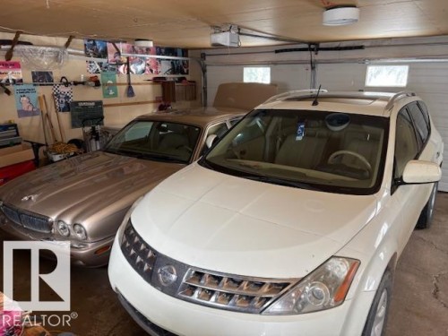 The property includes a garage featuring a wooden ceiling and a garage door with translucent window panels - 4809 53 Ave, Willingdon, AB - Indoor Photo Showing Garage