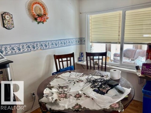 This dining area features a large window with privacy blinds, allowing for natural light - 4809 53 Ave, Willingdon, AB - Indoor