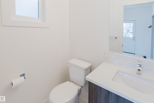 Bathroom featuring a white toilet, a vanity with a white countertop and a rectangular sink, and a chrome faucet - 9612 72 Avenue, Edmonton, AB - Indoor Photo Showing Bathroom