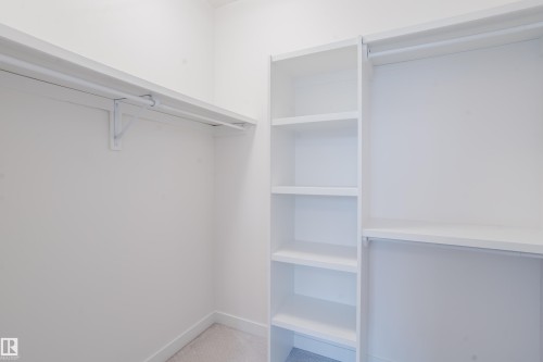Closet featuring built-in shelving, hanging rods, and carpeted flooring - 9612 72 Avenue, Edmonton, AB - Indoor With Storage