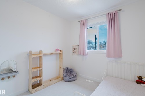 This room features light-colored walls and carpeting, creating a bright and open atmosphere - 9612 72 Avenue, Edmonton, AB - Indoor