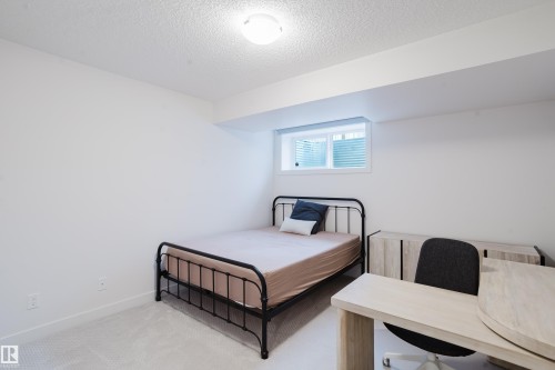 This room features light-colored carpeting and white walls, creating a bright and airy atmosphere - 9612 72 Avenue, Edmonton, AB - Indoor Photo Showing Bedroom