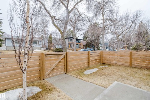 The property features a newly installed wooden fence, a private gate, and a concrete pathway - 9612 72 Avenue, Edmonton, AB - Outdoor