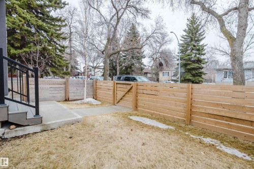 The property features a concrete walkway leading to the entrance, a wooden fence, and a gate - 9612 72 Avenue, Edmonton, AB - Outdoor