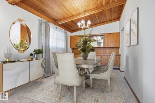 Dining area featuring a vaulted wood plank ceiling, a built-in wood cabinet with upper storage, and a window with sheer curtains - 9131 74 Street, Edmonton, AB - Indoor Photo Showing Dining Room