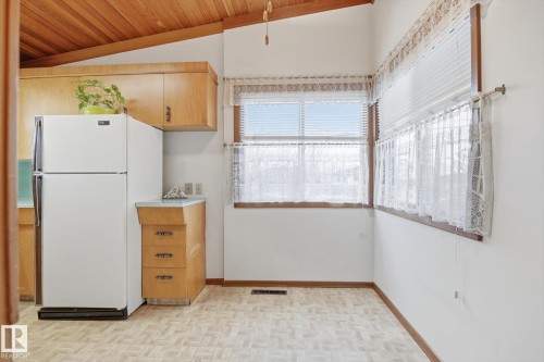 Kitchen area featuring wood cabinetry, a white refrigerator, and windows providing natural light - 9131 74 Street, Edmonton, AB - Indoor Photo Showing Other Room