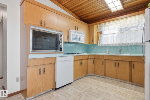 The kitchen features light wood cabinetry, a built-in oven, and a dishwasher - 9131 74 Street, Edmonton, AB - Indoor Photo Showing Kitchen