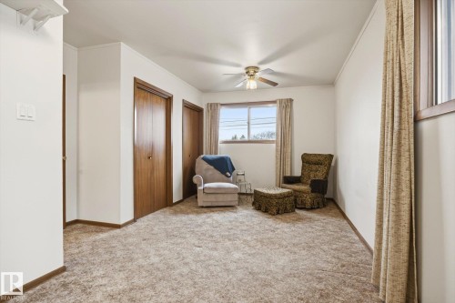 This room features a neutral-toned carpet, a window with curtains, and a ceiling fan - 9131 74 Street, Edmonton, AB - Indoor Photo Showing Other Room
