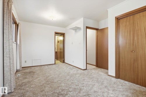 This room features light-colored carpeting, white walls, and wooden doors and trim - 9131 74 Street, Edmonton, AB - Indoor Photo Showing Other Room