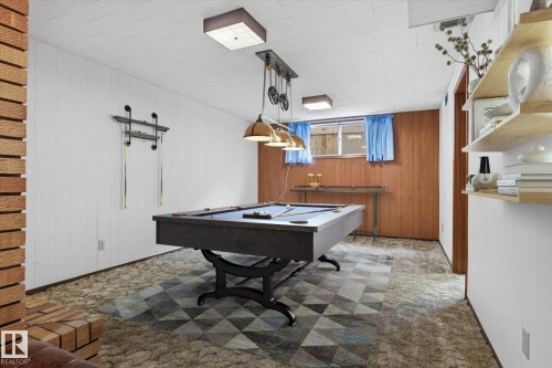 Recreation space featuring a pool table, wood paneling, and an exposed brick column - 9131 74 Street, Edmonton, AB - Indoor Photo Showing Other Room