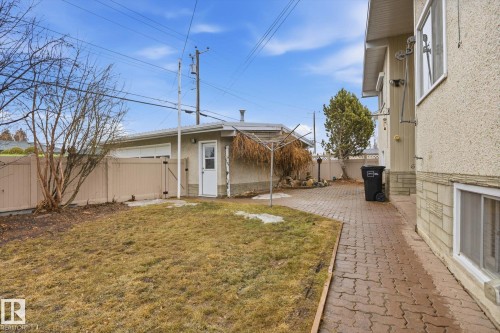 The property features a private yard with a paved patio, a detached garage, and a privacy fence - 9131 74 Street, Edmonton, AB - Outdoor