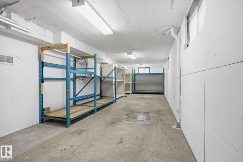 Basement storage area featuring concrete flooring, white walls, overhead lighting, and shelving units - 9131 74 Street, Edmonton, AB - Indoor