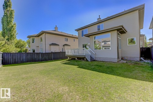 The property features an expansive lawn, a privacy fence, and a multi-level deck with white railings - 3105 Tredger Place, Edmonton, AB - Outdoor With Deck Patio Veranda