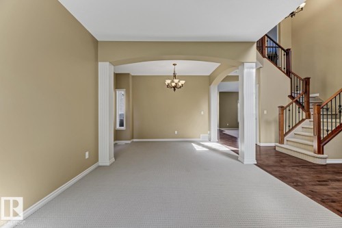 Spacious interior with neutral wall colors, a chandelier, and a carpeted area - 3105 Tredger Place, Edmonton, AB - Indoor Photo Showing Other Room