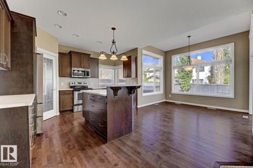 The kitchen and dining area feature rich hardwood flooring and recessed lighting - 3105 Tredger Place, Edmonton, AB - Indoor Photo Showing Kitchen With Upgraded Kitchen