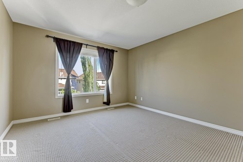 This room features a window with dark curtains, light-colored walls, and patterned carpeting - 3105 Tredger Place, Edmonton, AB - Indoor Photo Showing Other Room