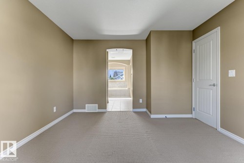 The property features an interior room with light brown walls and neutral-toned carpeting - 3105 Tredger Place, Edmonton, AB - Indoor Photo Showing Other Room