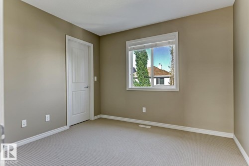 This room features neutral-toned walls, a window with white trim, and light-colored carpeting - 3105 Tredger Place, Edmonton, AB - Indoor Photo Showing Other Room