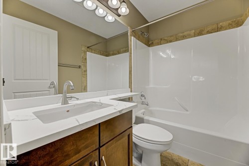 The bathroom features a modern vanity with a white countertop and an integrated rectangular sink - 3105 Tredger Place, Edmonton, AB - Indoor Photo Showing Bathroom