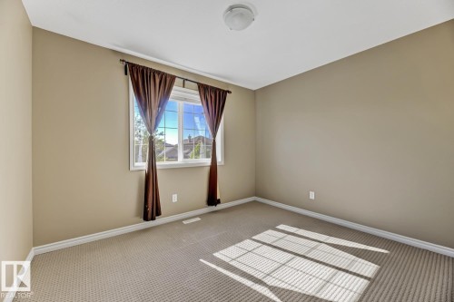 This room features a window with brown drapes, carpeted flooring, and light-colored walls - 3105 Tredger Place, Edmonton, AB - Indoor Photo Showing Other Room
