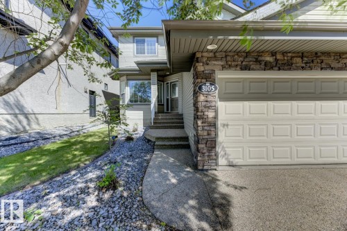 The property features a stone and siding exterior, an attached garage, and a concrete driveway - 3105 Tredger Place, Edmonton, AB - Outdoor