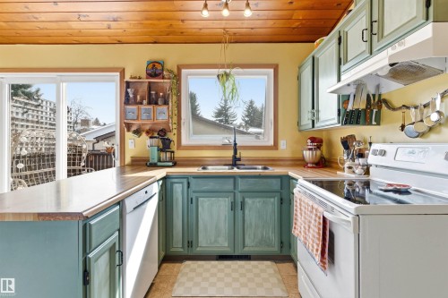 Kitchen featuring wood plank ceilings, a window above the sink, light wood countertops, and painted cabinetry - 18315 68 Avenue, Edmonton, AB - Indoor Photo Showing Kitchen With Double Sink