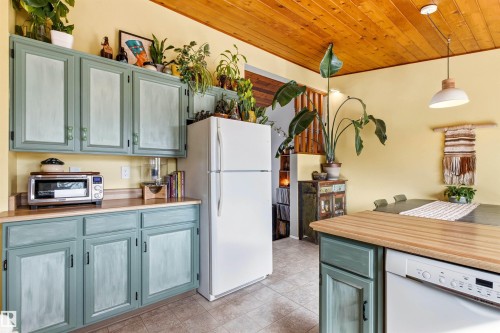 The kitchen features light blue painted cabinetry, wood countertops, and a wood plank ceiling - 18315 68 Avenue, Edmonton, AB - Indoor Photo Showing Kitchen