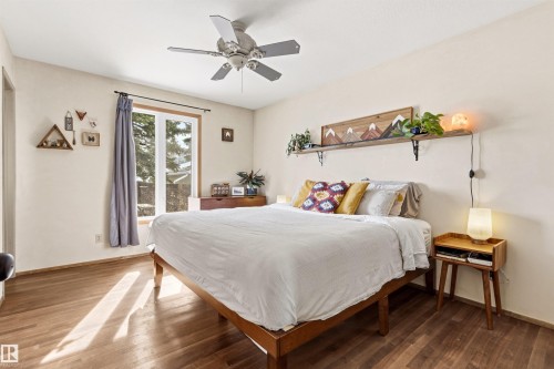 This room features hardwood flooring, a ceiling fan, and a window with a view of exterior trees - 18315 68 Avenue, Edmonton, AB - Indoor Photo Showing Bedroom