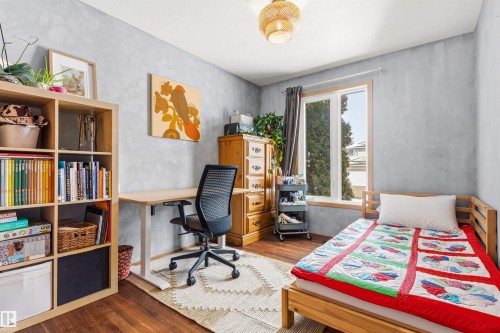 The room features hardwood floors, a large window providing natural light, and a ceiling light fixture - 18315 68 Avenue, Edmonton, AB - Indoor Photo Showing Other Room