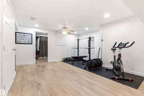 Spacious room with light-colored flooring, white walls, and a ceiling fan - 18315 68 Avenue, Edmonton, AB - Indoor Photo Showing Gym Room