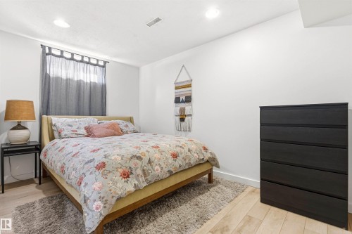 The property features light wood flooring, white walls, and recessed lighting - 18315 68 Avenue, Edmonton, AB - Indoor Photo Showing Bedroom