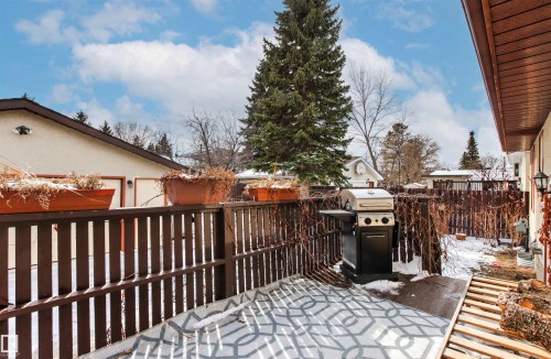 This property features a private outdoor area with a wooden fence and a textured outdoor rug - 18315 68 Avenue, Edmonton, AB - Outdoor With Deck Patio Veranda