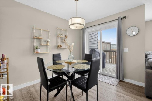 Dining area featuring light-toned walls, wood-style flooring, and a glass-top table with seating for four - 16656 14 Avenue, Edmonton, AB - Indoor Photo Showing Dining Room